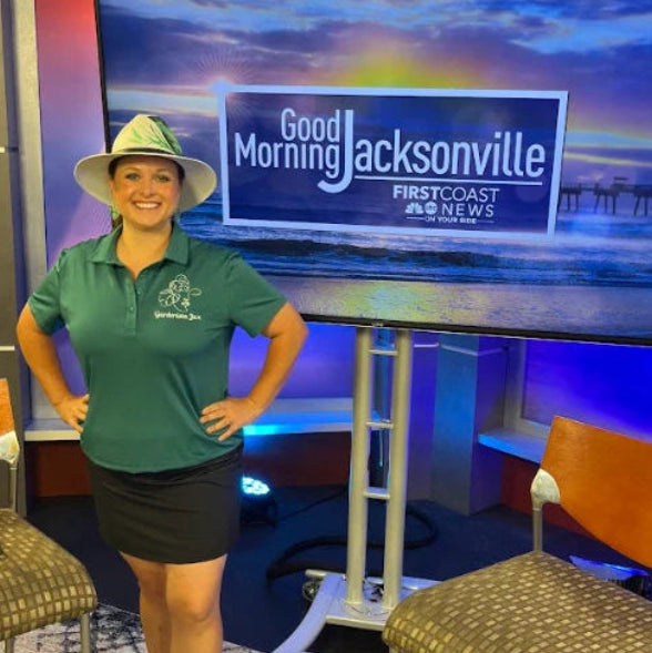 India standing in front of a TV that says good morning Jacksonville